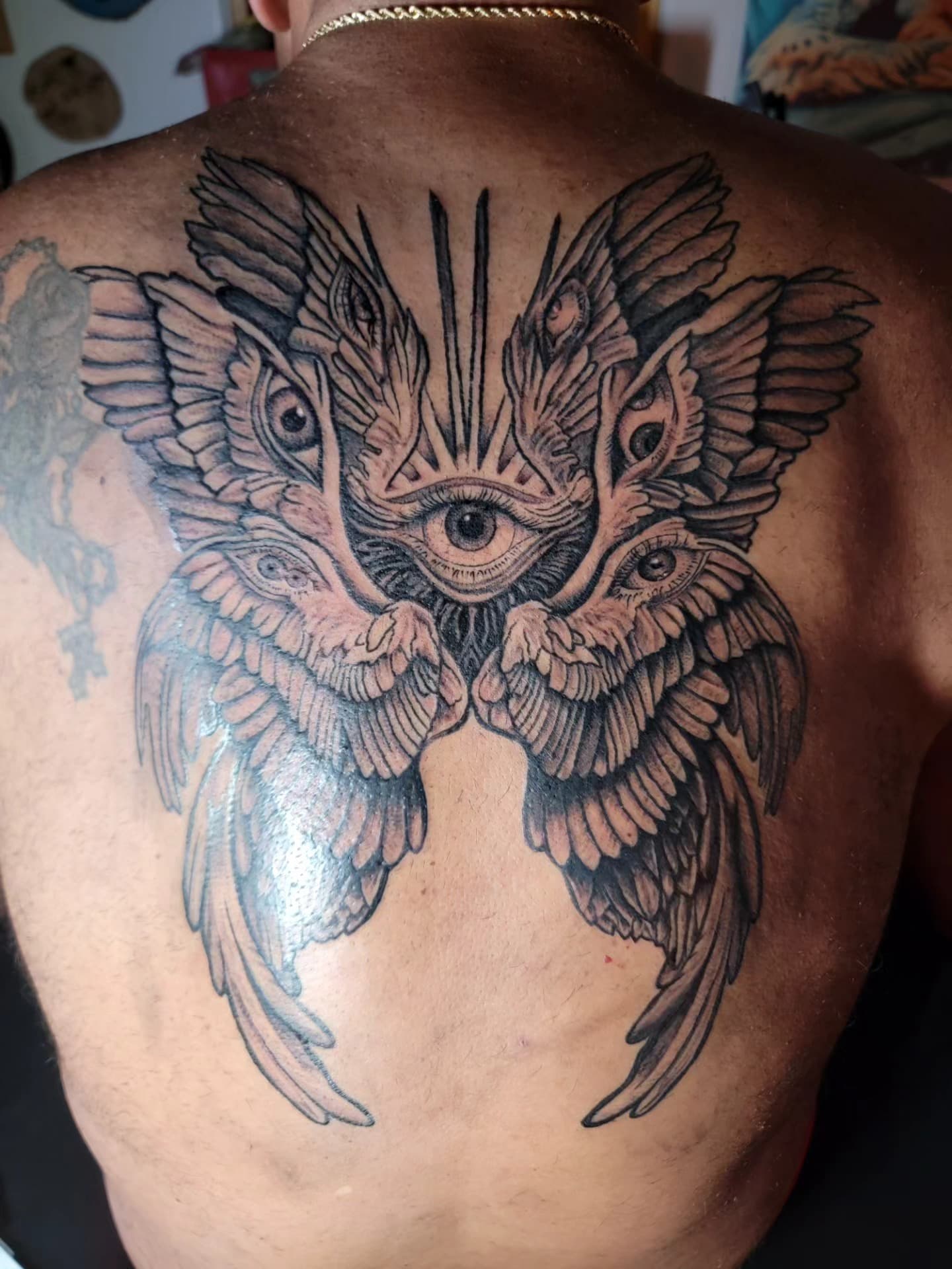 Symmetrical winged eye back tattoo