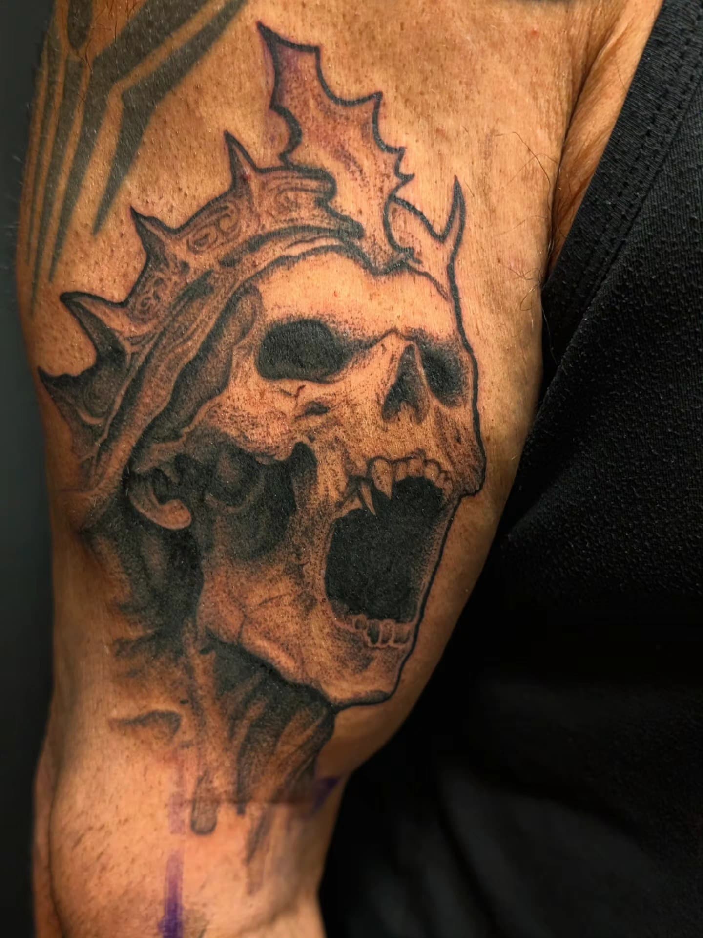 Skull with crown-like spikes tattoo