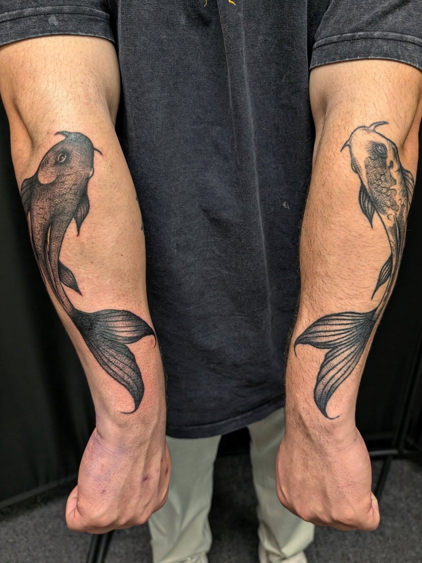 Matching fish tattoos on forearms