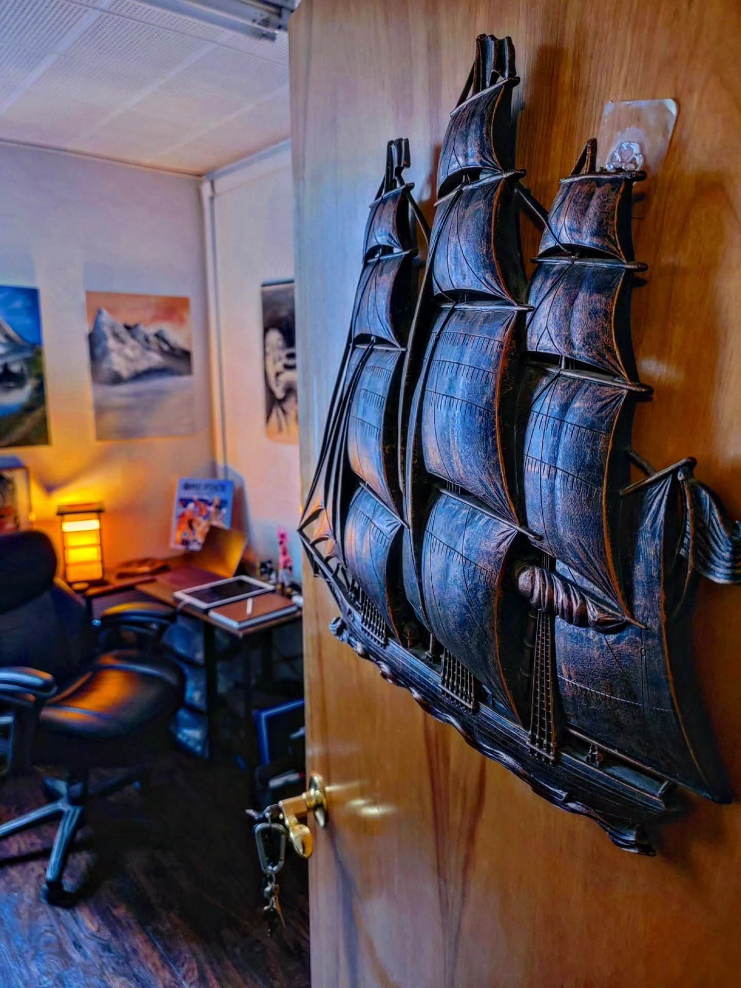 Black wooden sailing ship model on the studio wall